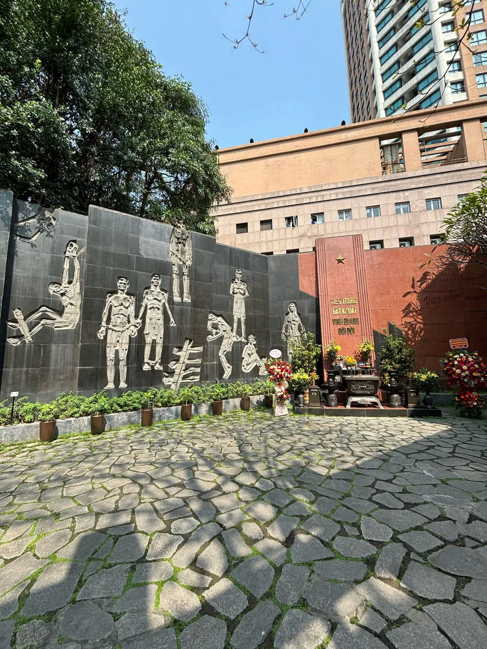 Gedenkmuur bij de Hoa Lo gevangenis in Hanoi met reliëfsculpturen van gevangenen