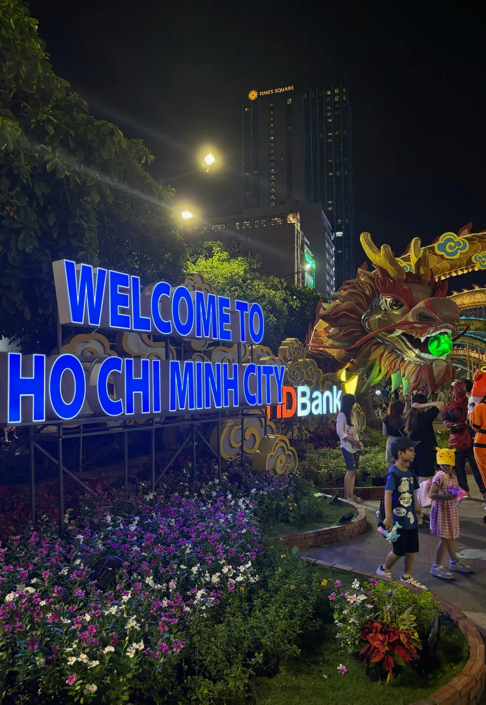 Welcome to Ho Chi Minh City bord verlicht bij nacht met een drakendecoratie