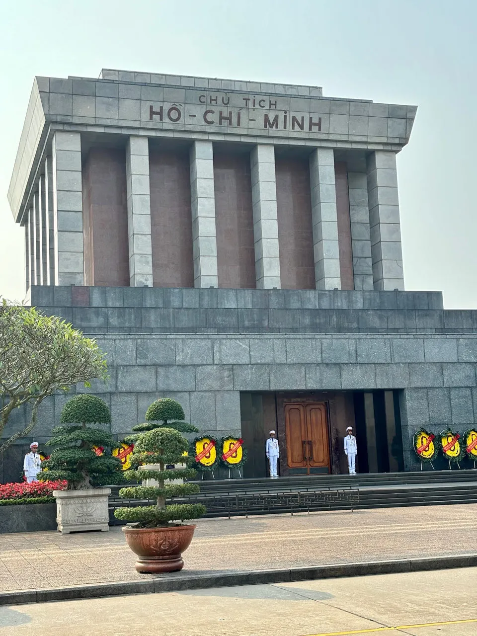 Ho Chi Minh mausoleum met witte bewakers in uniform voor de grijze granieten gevel